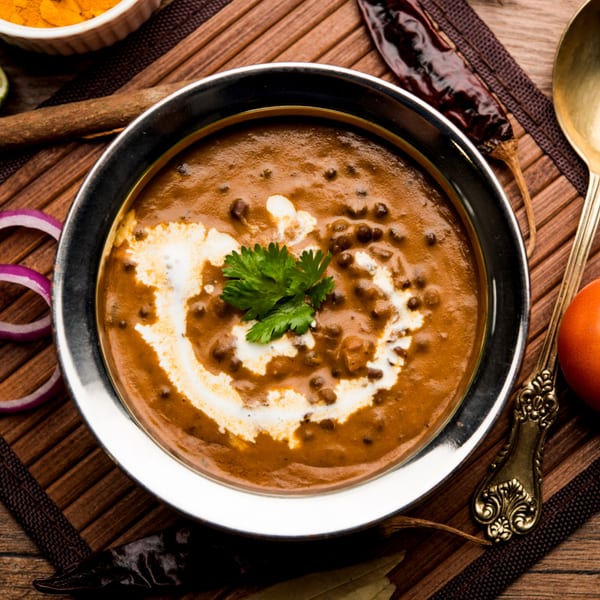 A bowl of Indian Wok's creamy Dal Makhani, garnished with fresh cilantro and a swirl of cream.